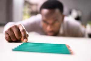 Man with OCPD organizing green pencils on a desk