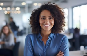 Young african american woman standing in an office with her arms crossed and looking at the camera