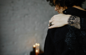 Woman in mourning is comforted by hand around her shoulder