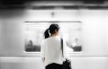 woman in white shirt standing in front of subway