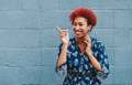 woman with red hair laughing by blue wall