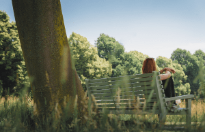 red haired woman city on bench beside tree