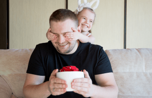 father receiving a surprise from daughter