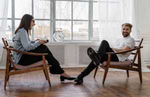 2-women-sitting-on-brown-wooden-chair