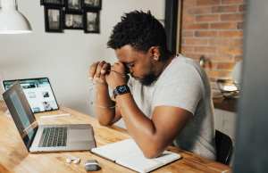 man-in-gray-crew-neck-t-shirt-sitting-on-chair-in-front-of-macbook-pro