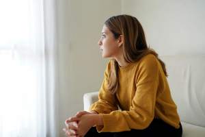 Woman sitting on a couch looking out a window