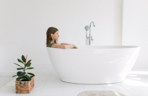 Woman sits in bathtub fully clothed