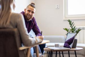 White man in plaid shirt talking to white therapist