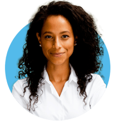 Woman with black curly hair and white shirt looking straight forward and grinning.