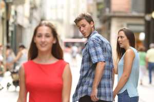 Disloyal man with his girlfriend looking at another girl