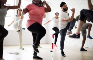 Diverse people exercising in gym class together