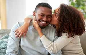 Happy African-American couple kissing on the couch