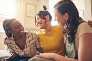 Three women talking and embracing