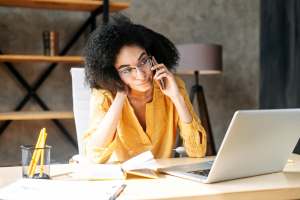 Woman calling someone while working on a laptop