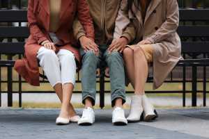 Two women and a man sitting on a bench