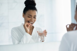 Woman taking medication with water