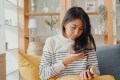 Woman holding prescription medication bottle and her phone