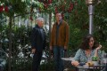 A scene from Apple TV+'s Shrinking showing three characters in an outdoor garden setting surrounded by flowering vines