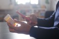 Person using smartphone to look up information on a medication, while holding a prescription medicine bottle in the other hand