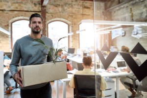 Man quitting his job, walking out with a box of his things